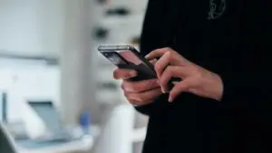 A small business owner reviewing Facebook ad copy on a laptop next to a notepad of headline ideas.