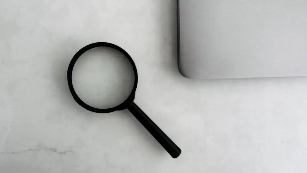 Small business owner reviewing a marketing agency invoice and contract at a desk with a laptop and calculator