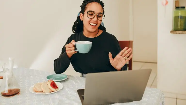 Small business owner reviewing marketing campaign results on a laptop during a video call with her agency team